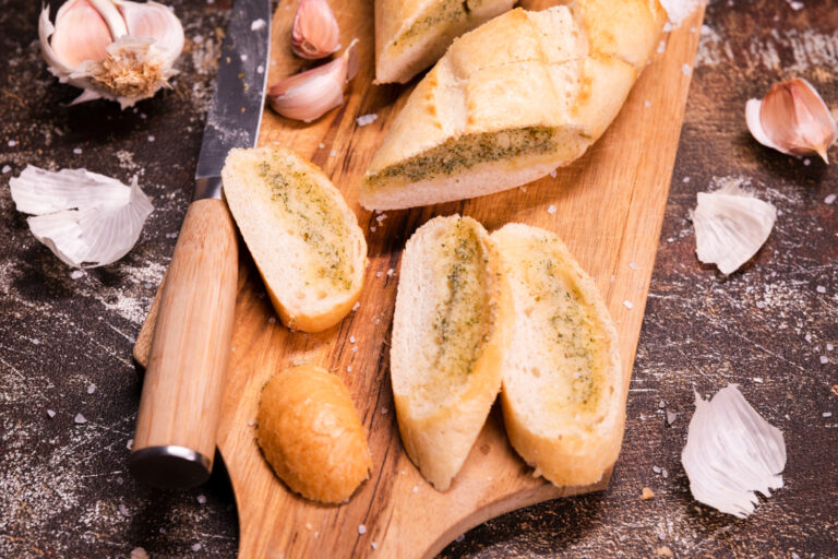 fatias de pão de alho numa tábua de madeira